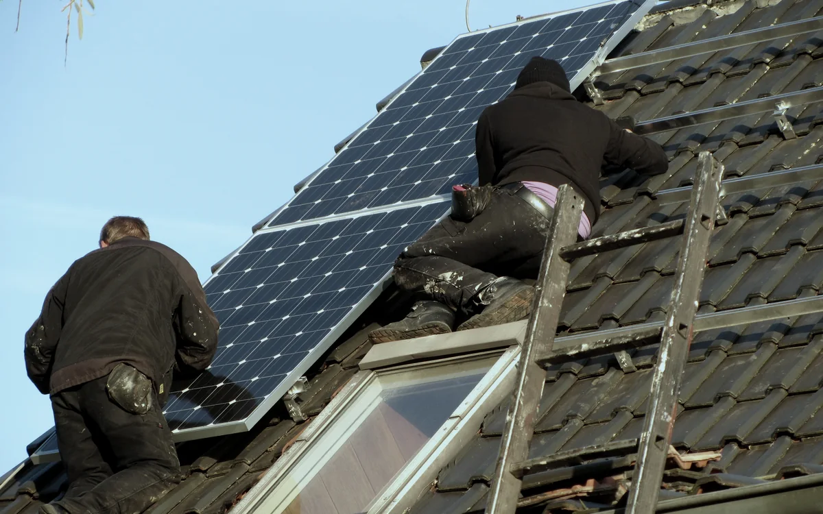 Instaladores certificados montando paneles solares en un tejado